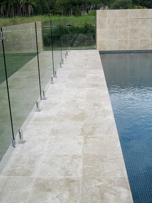 Click to return to the previous page Travertine Linen stone pool feature wall and tiling and coping and glass pool fence